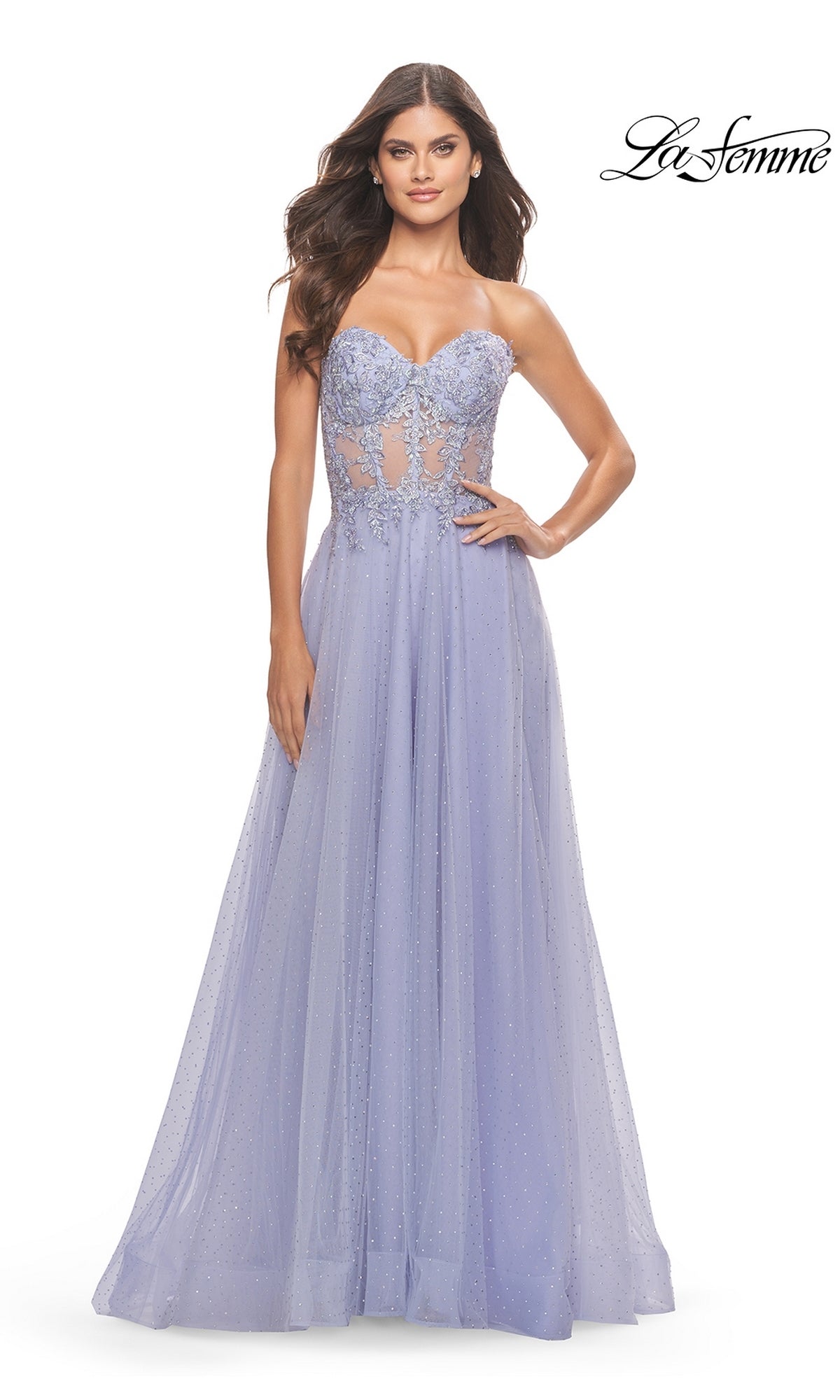 A woman poses against a white background in the La Femme Strapless Sheer-Waist Prom Dress 31367, featuring a lavender hue, beaded bodice, sheer waist detail, and an elegant A-line tulle skirt. The La Femme logo is in the top right corner.